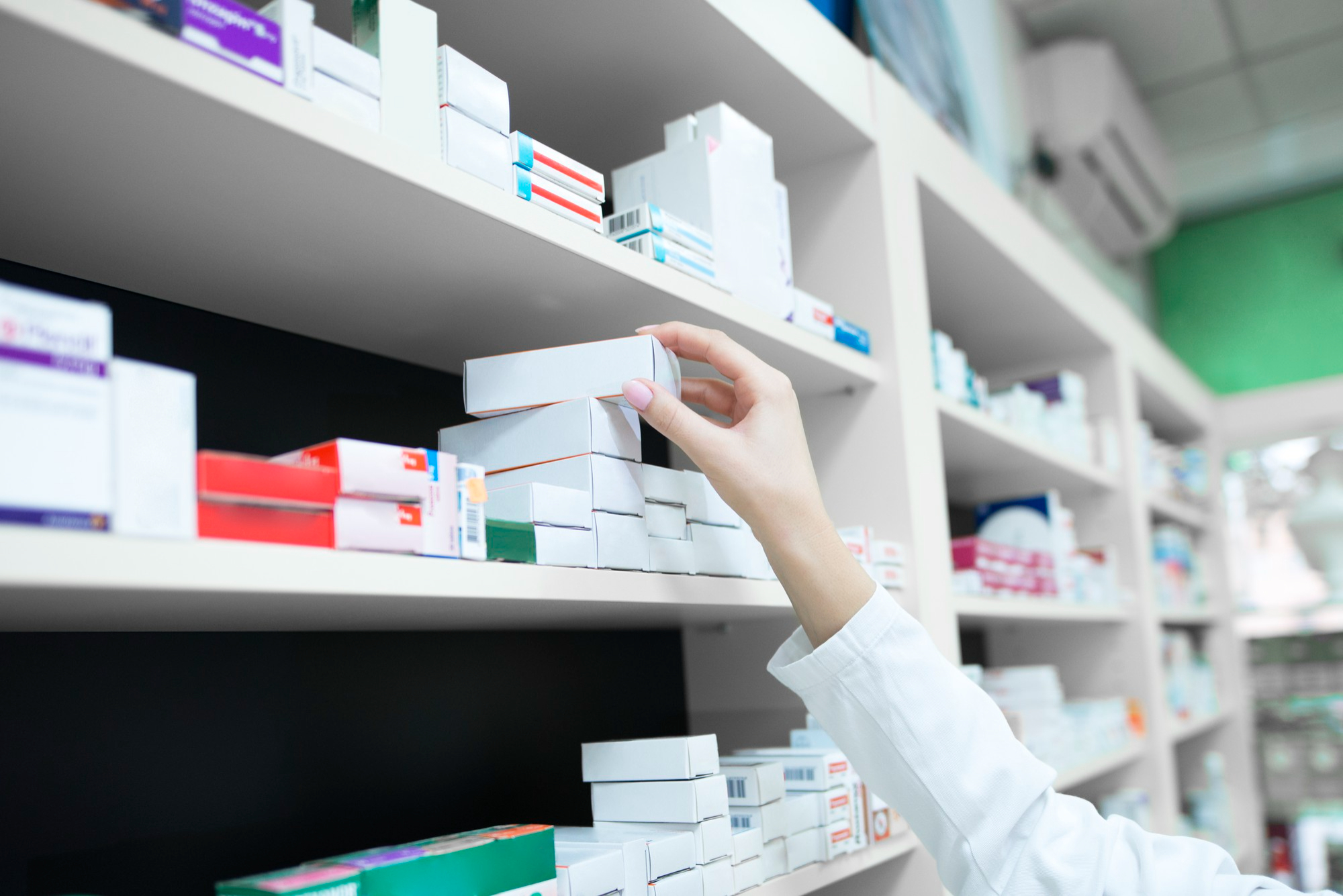closeup-view-of-pharmacist-hand-taking-medicine-box-from-the-shelf-in-drug-store